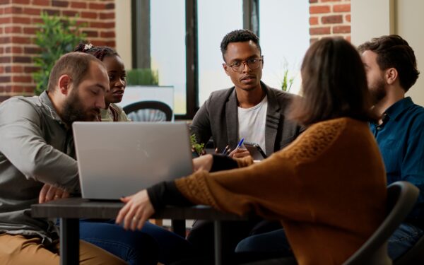 team of 5 casually dressed business coworkers brainstorming ideas at an office