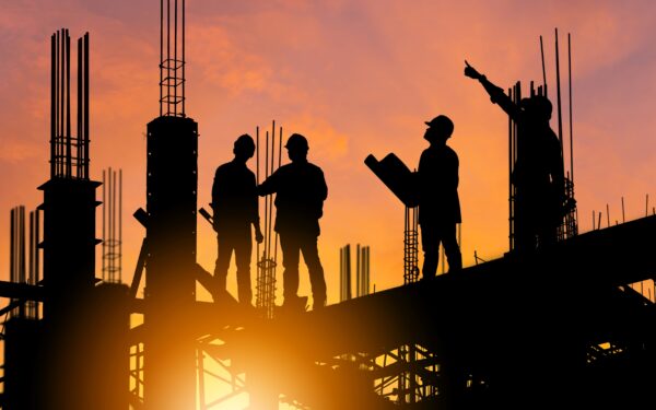 Silhouettes of 4 construction workers against a sunset