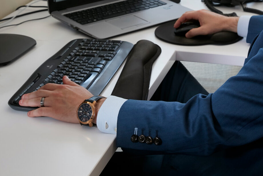 Pair of hands typing on computer and using mouse