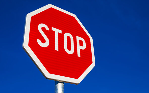 Stop sign against blue cloudless sky