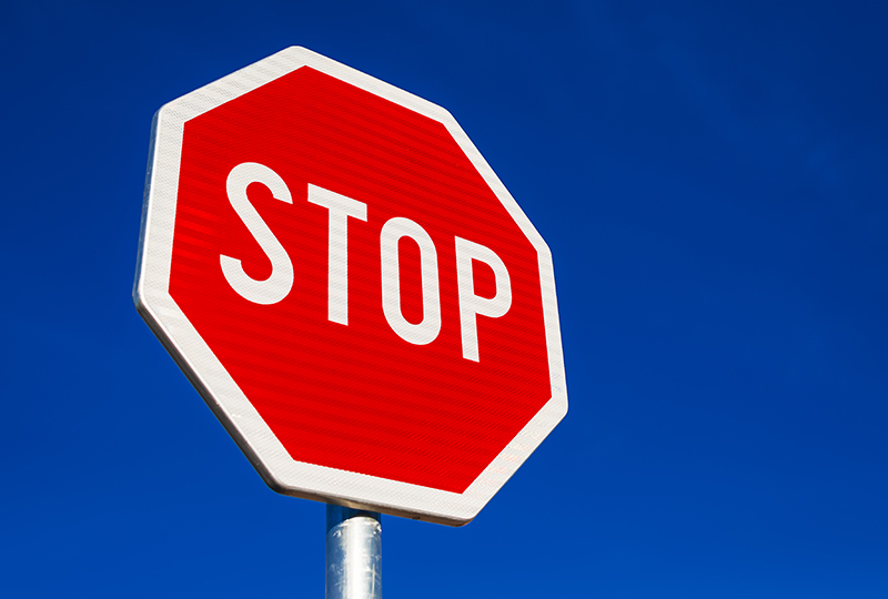 Stop sign against blue cloudless sky